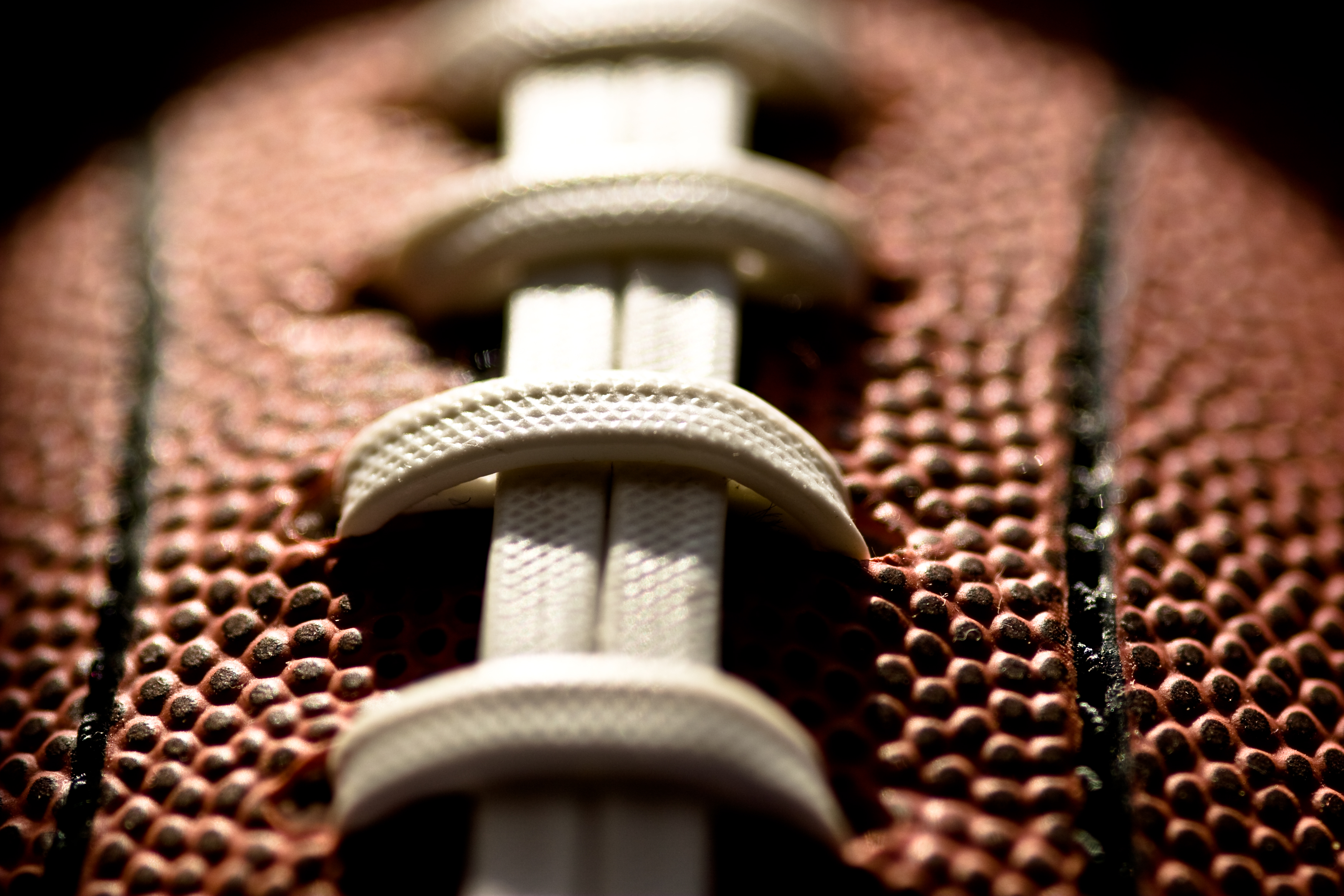 top of the football is illuminated with artistic lighting with lighting just on the laces and standard equipment for football football ball