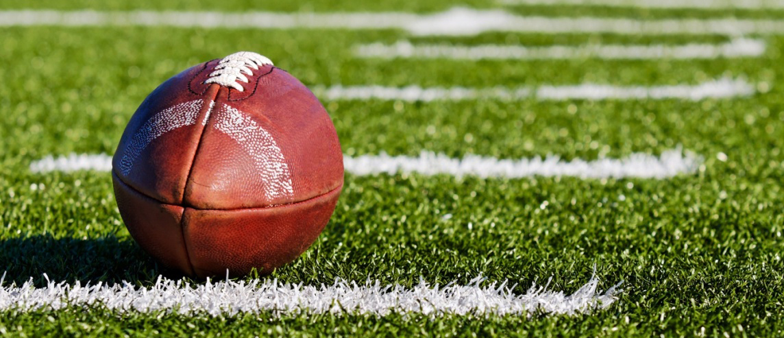 american football laying on a field with the laces pointing up official high school standard equipment football ball