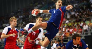 man taking a a shot on goal while jumping in the air using official regulated handball equipment ball