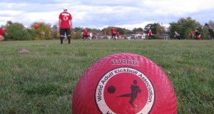 WAKA regulated kickball ball in foreground with a kickball game going on in the background basic equipment for kickball regulated WAKA kickball ball