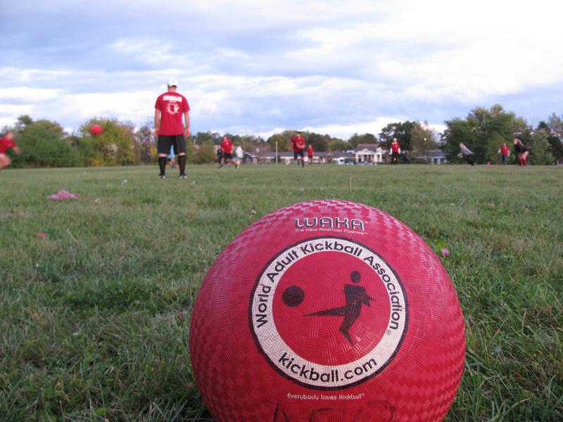 WAKA regulated kickball ball in foreground with a kickball game going on in the background basic equipment for kickball regulated WAKA kickball ball
