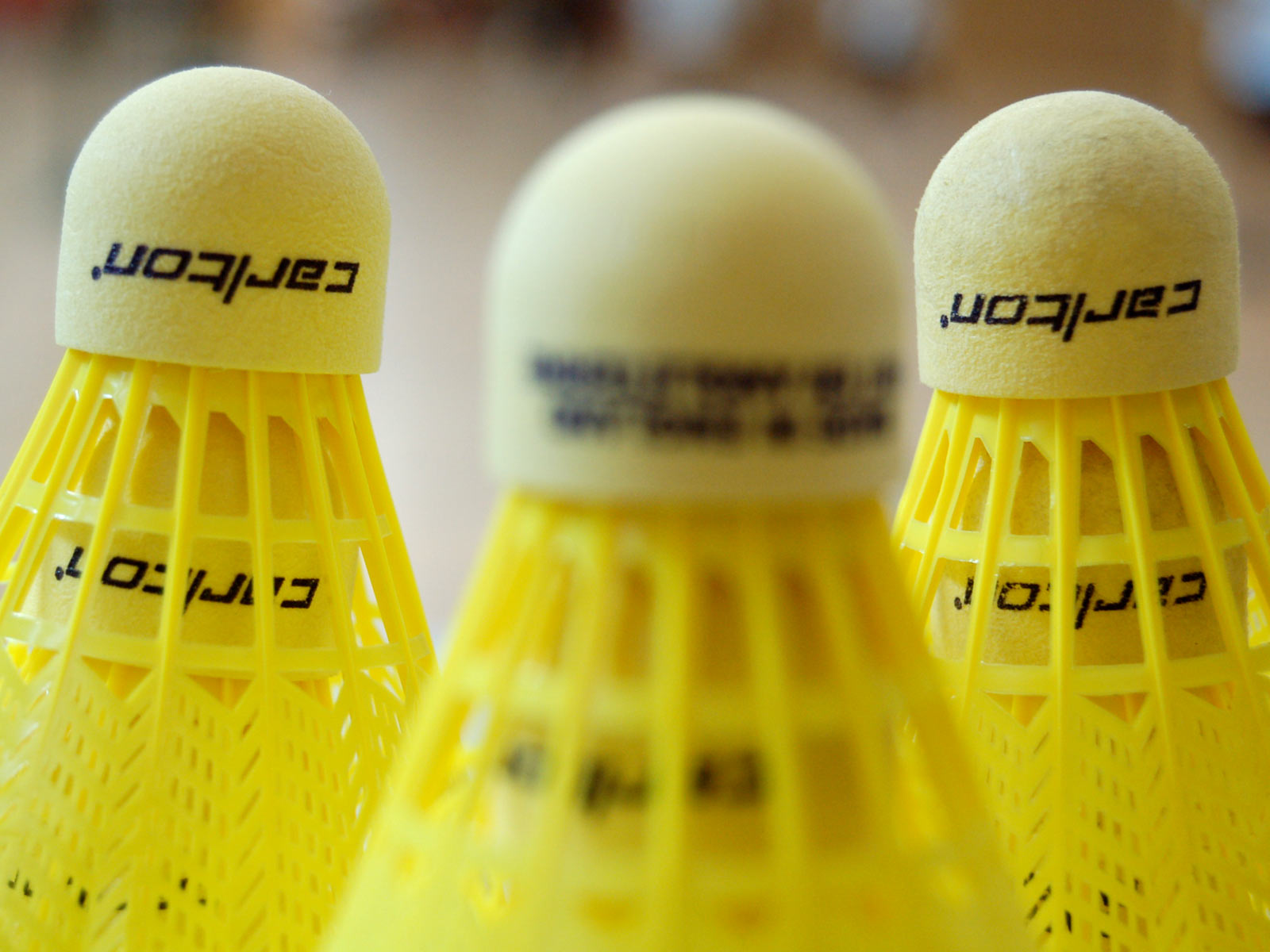 3 yellow shuttlecocks small ball with plastic yellow "feathers" coming out of the back basic badmiton equipment shuttlecock ball