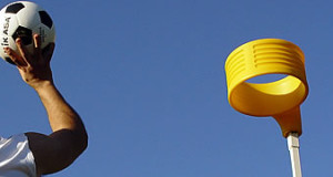 man shooting ball into korfball net yellow ring on top a pole basic equipment for korfball
